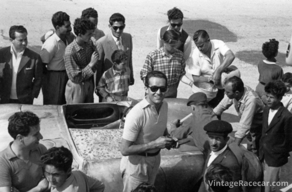 Umberto Maglioli stands beside his Porsche 550A and looks up from the pits during a break in open practice for the 1955 Targa Florio. The car arrived in Sicily with a bare metal body that was painted white before the race. Photo: Porsche 