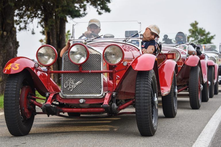 Line of red cars on road during 2021 Mille Miglia