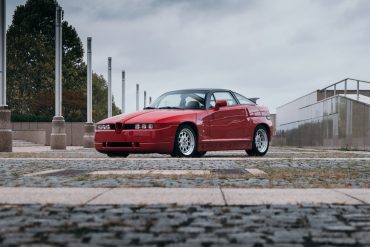 Red Alfa Romeo SZ on cobblestones in city