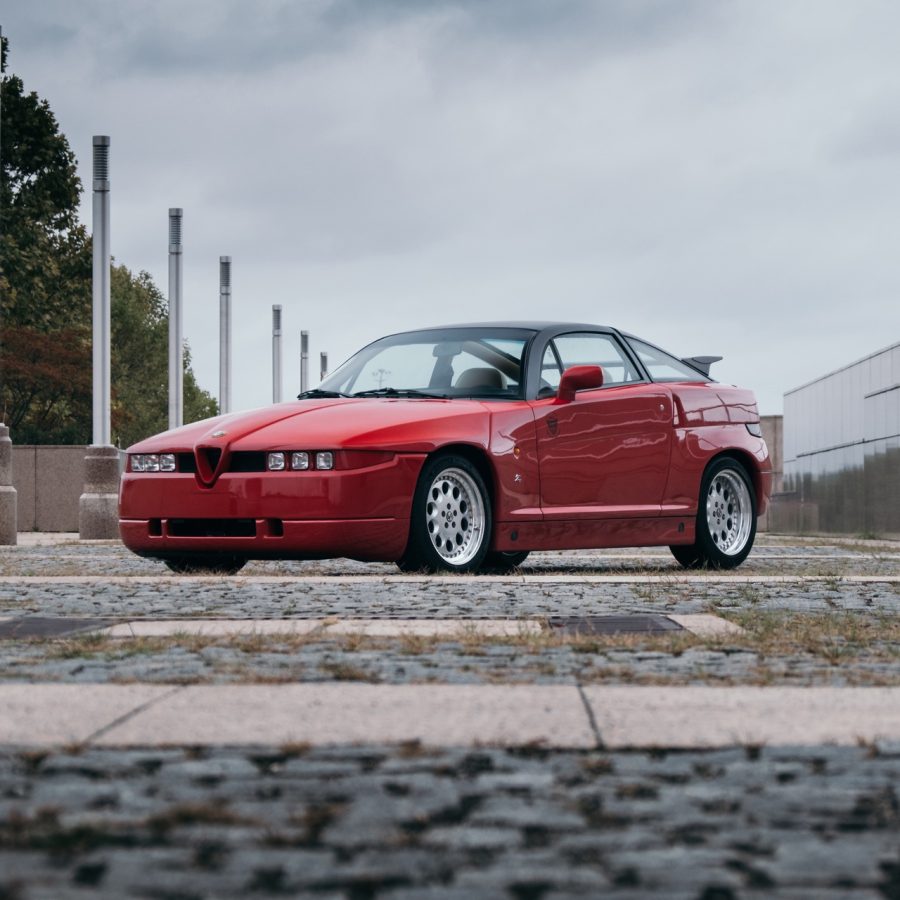 Red Alfa Romeo SZ on cobblestones in city