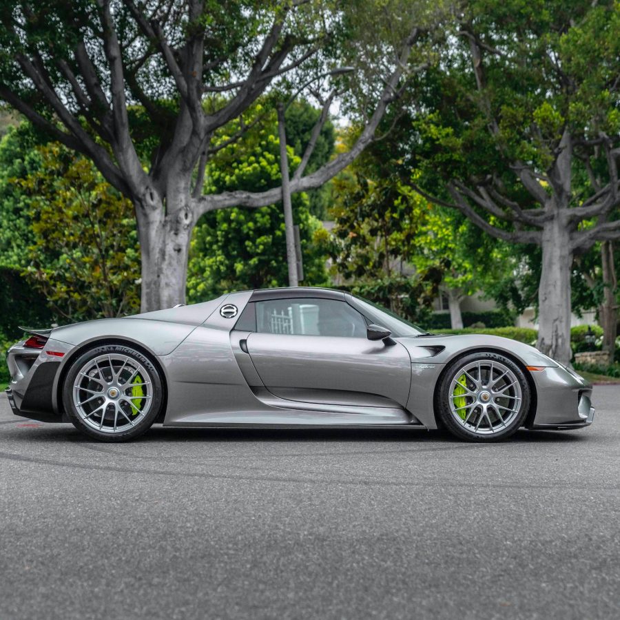 Silver 2015 Porsche 918 Spyder Weissach Edition on road with trees in background