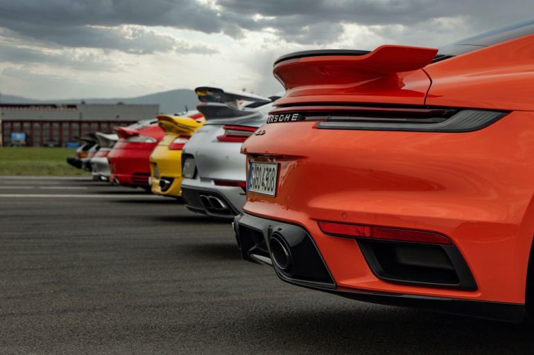 Row of Porsche cars in multiple colors on road