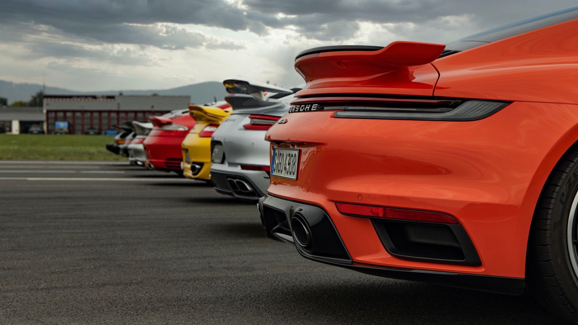 Row of Porsche cars in multiple colors on road